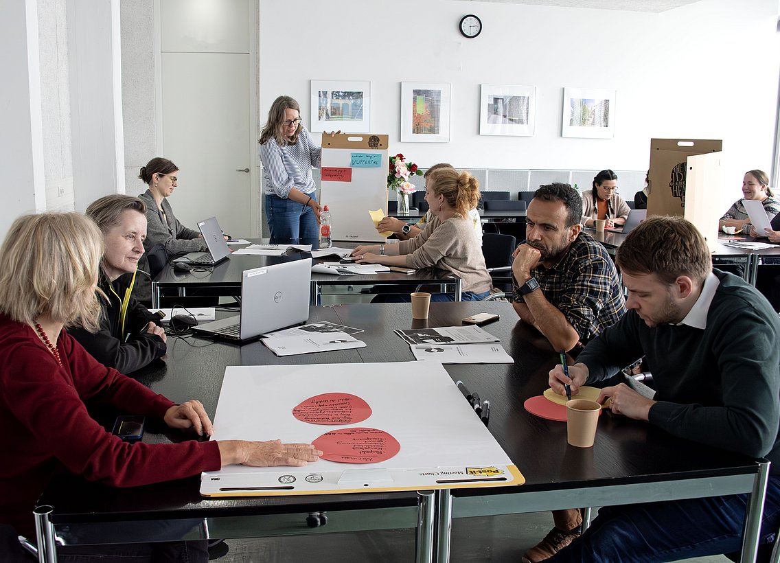 Universitätsmitglieder arbeiten kollaborativ in einem Seminarraum